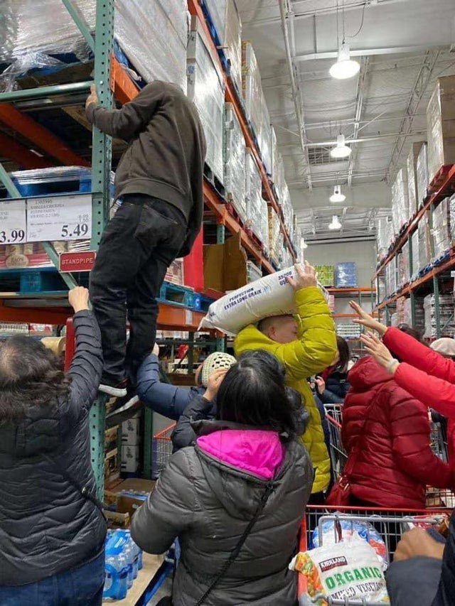 Покупатели достают крупы с верхних ярусов склада Costco